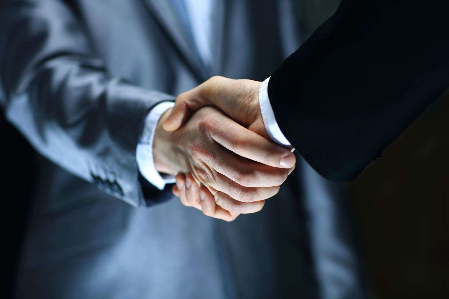 Handshake – Hand holding on black background
